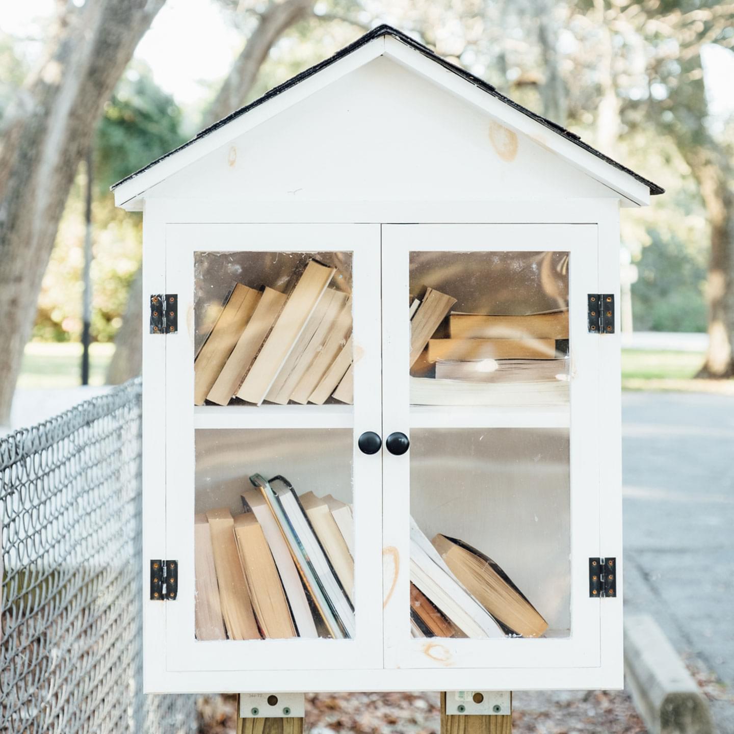 A photograph of a personal library holder housed outside where people can take or donate books for public sharing